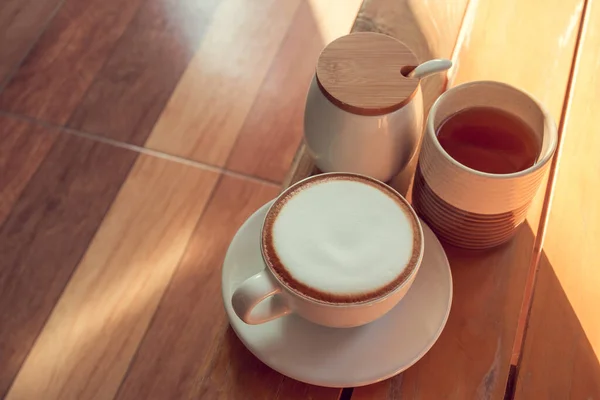 Cappuccino Cup Tea and sugar cups on a wooden table