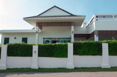 Evin beyaz beton çitleri ve ağaç çitleri var..