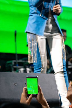 İnsanlar yaşamak için cep telefonu kullanıyor ya da konserlerde fotoğraf çekiyor, geceleri parlak ışıklar altında..