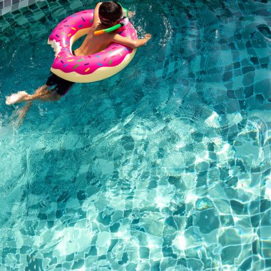 Çocuk havuzda yüzmekten çok mutlu. Aile tatili kavramı