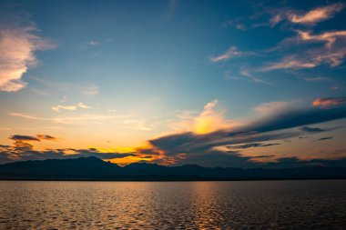 Güzel günbatımı gökyüzü ve gölün üzerindeki bulutlar.
