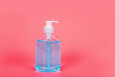 Pembe Arkaplanda bakteri ve virüs için alkol jeli temizleyicileri, Coronavirus 'u önlemek için alkol jeli kullanan insanlar (COVID-19)
