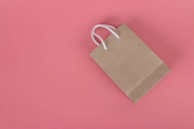 Pastel pembe arka planda kağıt torbalar, çevre koruma kavramı.