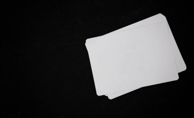 Siyah ahşap ofis masasında beyaz, boş bir kağıt.