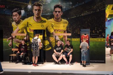 Çocuklar stand ve Bvb reklam önünde oturmak