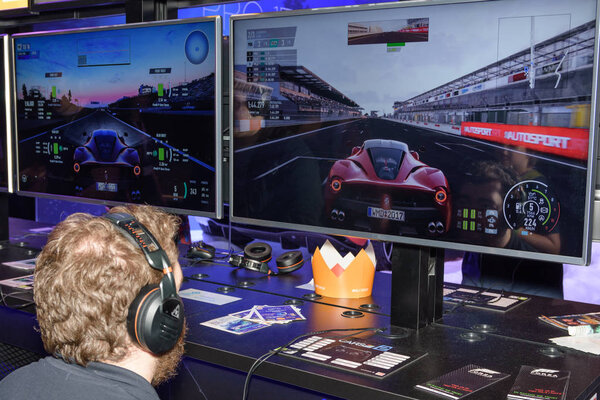 A trade fair visitor is playing the project cars 2 game