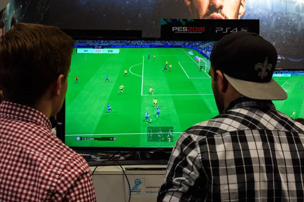 Два справедливых посетителей играют в игру Pro Evolution Soccer — стоковое фото