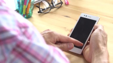 İşadamı pembe Scott gömlek slayt ve yakınlaştırma ve dokunmatik Smartphone ev ofis omuz görünümünde izleyin. Küçük işletme veya iş start-up. Merhaba 4k çözünürlüklü görüntüleri 3840 x 2160