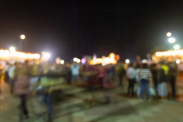 Blurred Crowd and Light in Night Scene and Brown Shirt Human at Left Frame