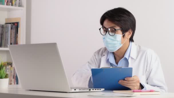 Azjatycki Lekarz Nosić Maskę Okulary Spotkanie Online Kolegą Przez Laptop — Wideo stockowe