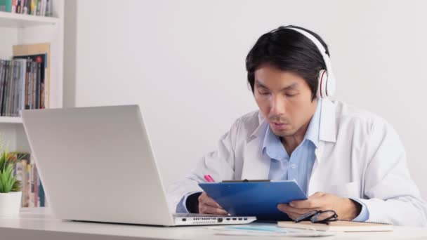 Asiatische Männliche Ärzte Tragen Kopfhörerberichte Und Meeting Pass Videokonferenz Laptop — Stockvideo