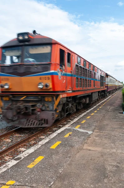 Bir tren Tayland 'da kırsal bir istasyondan geçiyor.