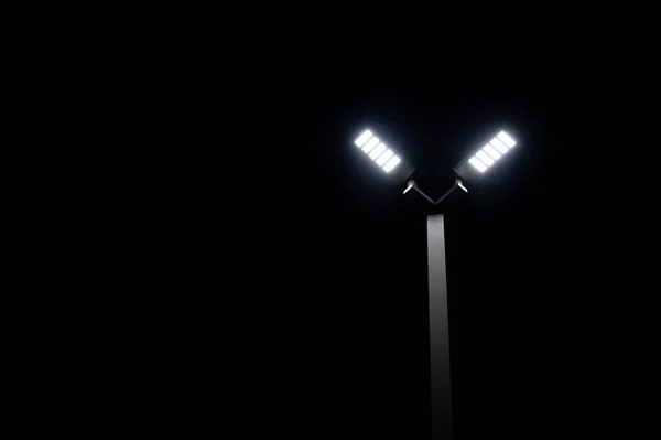 A couple of LED street light glows under the night time dark sky