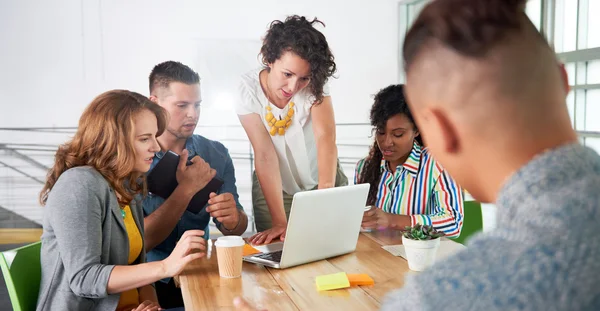Многонациональная группа успешных креативных бизнесменов, использующих ноутбук во время откровенной встречи — стоковое фото