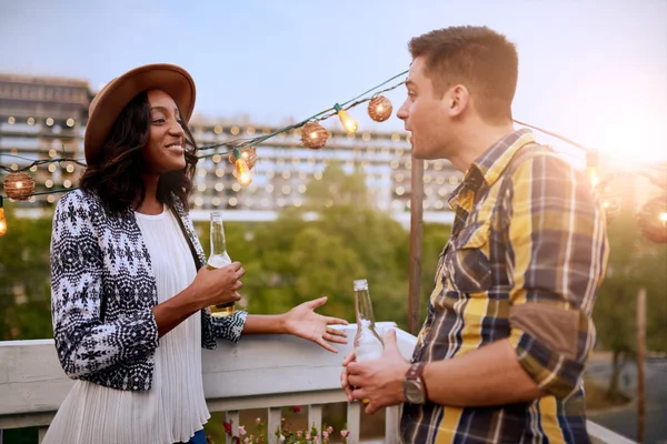 Multietnické millenial pár flirtování při skleničce na střešní terase při západu slunce — Stock fotografie