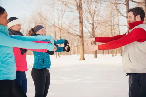 Group of friends stretching in the snow in winter — Stock Photo, Image