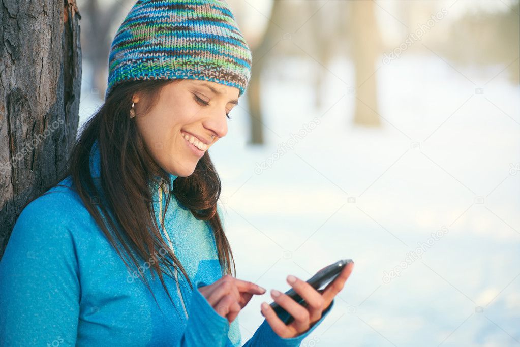 Attractive mixed race woman using a mobile phone in the park at