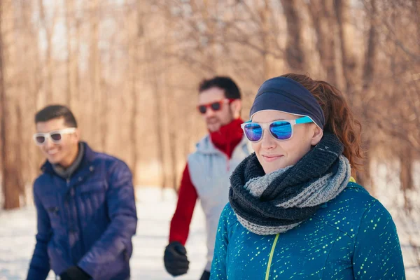 Group of friends exercising in the snow in winter — Stock Photo, Image