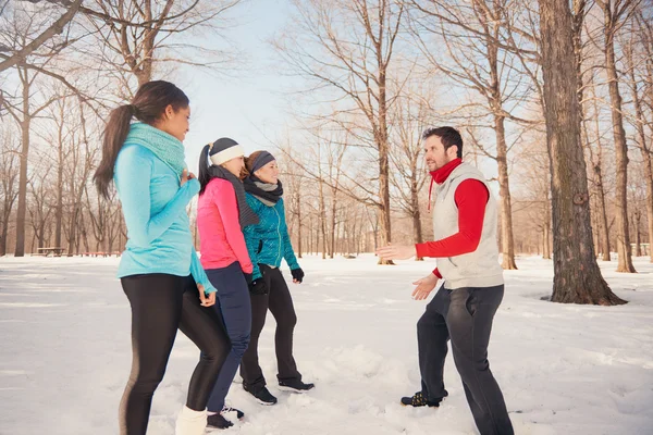 Group of friends stretching in the snow in winter — Stock Photo, Image