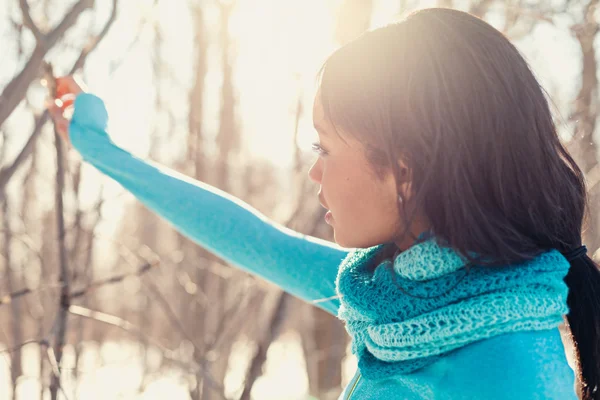 Young black woman holding a tree in the snow in winter — Stockfoto