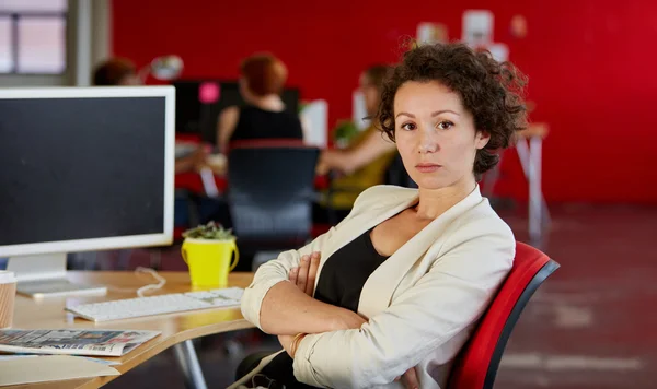 Уверенная женщина-дизайнер, работающая в красном креативном офисе — стоковое фото