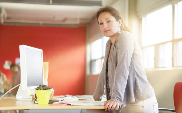 Diseñadora femenina segura que trabaja en el espacio de oficina creativo rojo — Foto de Stock