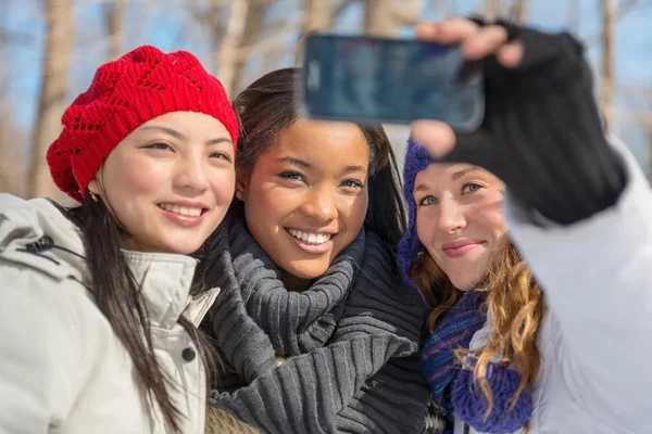 Grupo de amigas gostando de tirar selfies na neve no inverno — Fotografia de Stock