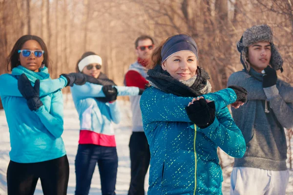 Group of friends stretching in the snow in winter — Stock Photo, Image