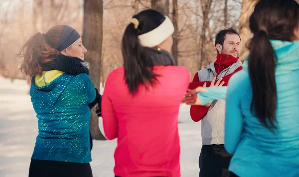 Group of friends stretching in the snow in winter — Stock Photo, Image