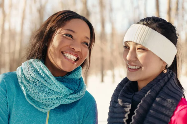 Ethnically-mixed duo of female friends talking in a park in winter — Stock Photo, Image