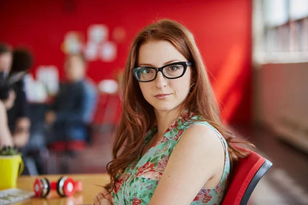 Diseñadora femenina segura que trabaja en el espacio de oficina creativo rojo —  Fotos de Stock
