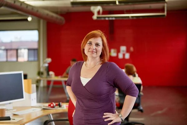 Уверенная женщина-дизайнер, работающая в красном креативном офисе — стоковое фото