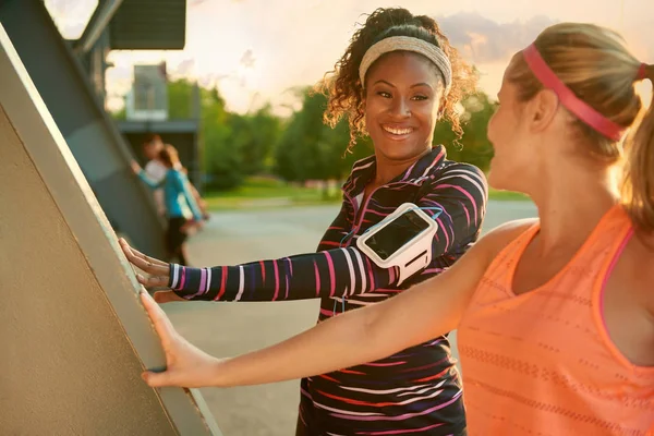 Female athletes stretching before going jogging outdoors — Stock Photo, Image