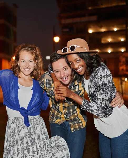 Grupo multi-étnico milenar de amigos tirando uma foto selfie com telefone celular no terraço do telhado usando flash à noite — Fotografia de Stock