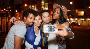 Çok etnik gruptan oluşan millenial grup arkadaşıyla gece zaman flash kullanma çatı terrasse üzerinde cep telefonu ile selfie fotoğraf çekme