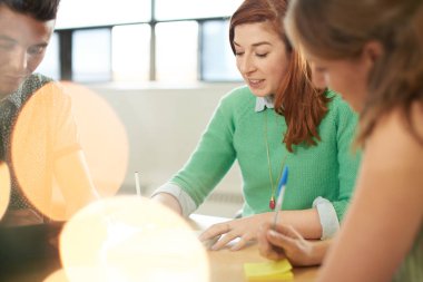 Yaratıcı iş girişimciler birlikte dijital tablet üzerinde beyin fırtınası bir açık kavram ofiste unposed grubu.