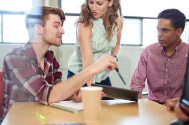 Yaratıcı iş girişimciler birlikte dijital tablet üzerinde beyin fırtınası bir açık kavram ofiste unposed grubu.