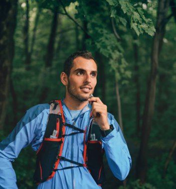 Gün eğitim için çapraz ülke orman iz yarış sırasında bir doğa parkında uygun erkek koşucu nemlendirir.