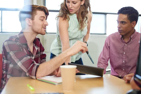 Yaratıcı iş girişimciler birlikte dijital tablet üzerinde beyin fırtınası bir açık kavram ofiste unposed grubu.