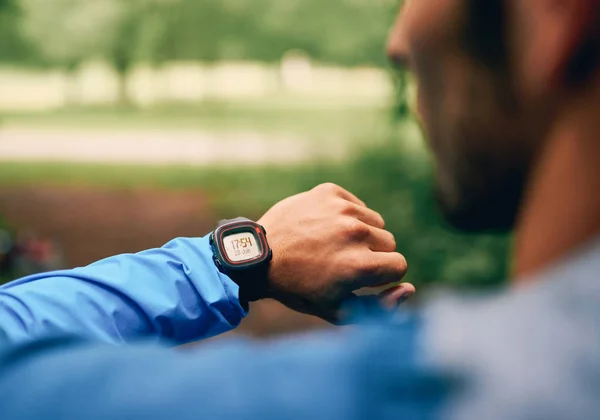 Вмістити чоловічий бігун день, використовуючи смарт-годинник під час перехресних кантрі лісових гонок стежки в природному парку . — стокове фото