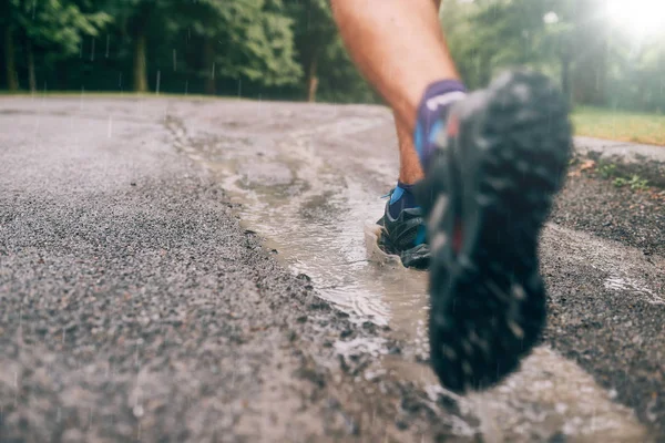 Muskulös kalvar av fit manliga jogger utbildning för gränsöverskridande land forest trail race i regnet på en naturstig. — Stockfoto