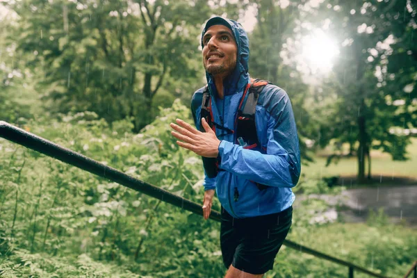 Fit male jogger day training in the rain for cross country forest trail race in a nature park. — Stock Photo, Image