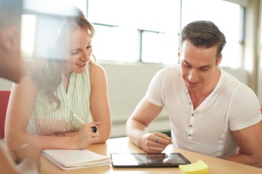 Yaratıcı iş girişimciler birlikte dijital tablet üzerinde beyin fırtınası bir açık kavram ofiste unposed grubu.
