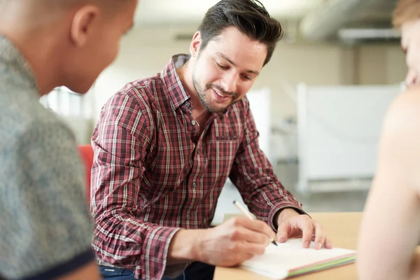 Ungestellte Gruppe kreativer Unternehmer in einem Großraumbüro Brainstorming auf einem digitalen Tablet. — Stockfoto