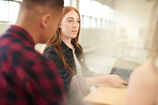 Unposed group of creative business entrepreneurs in an open concept office brainstorming together on a digital tablet. — Stock Photo, Image