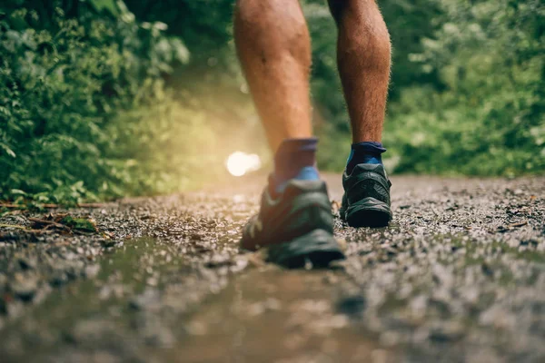 Terneros musculares de entrenamiento de jogger masculino en forma para la carrera de senderos forestales a campo traviesa bajo la lluvia en un sendero natural . — Foto de Stock