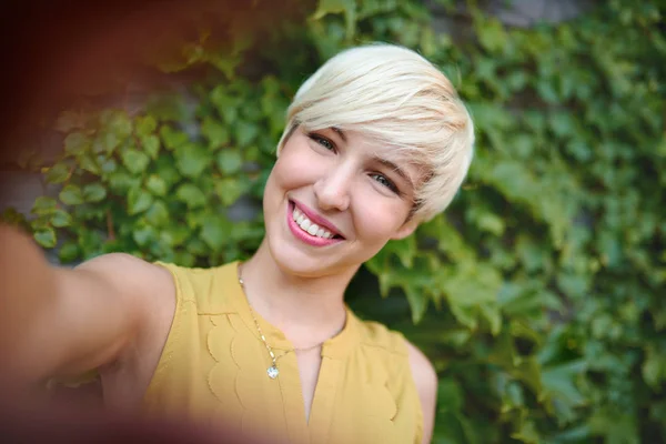 Atraktivní bílé žena selfie plot pozadí ivy — Stock fotografie