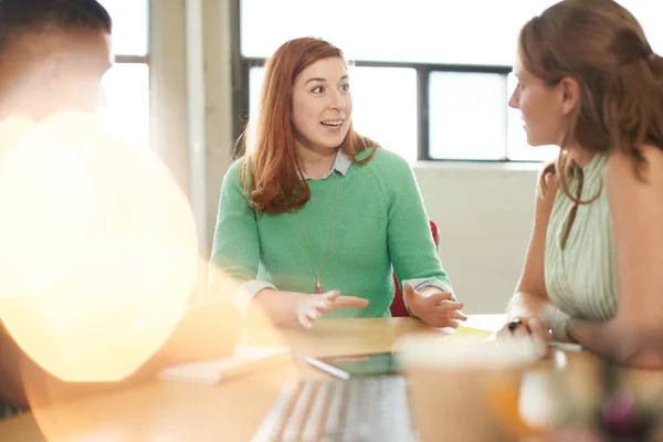 Unposed group of creative business entrepreneurs in an open concept office brainstorming together on a digital tablet. — Stock Photo, Image