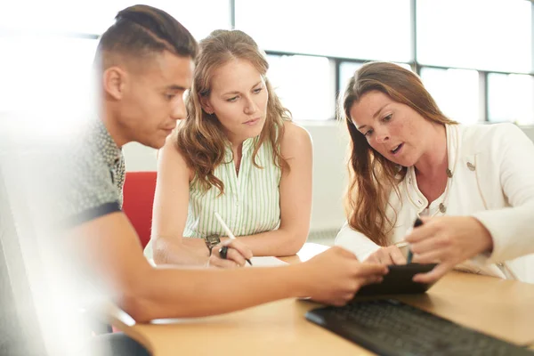 Grupo não representado de empresários criativos em um escritório de conceito aberto que faz brainstorming juntos em um tablet digital . — Fotografia de Stock