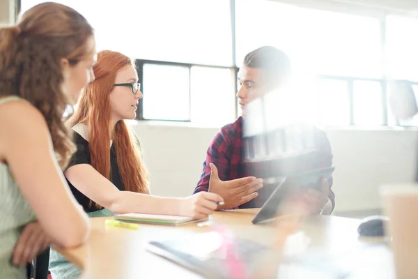 Gruppo di imprenditori creativi senza posa in un ufficio open concept brainstorming insieme su un tablet digitale . — Foto Stock